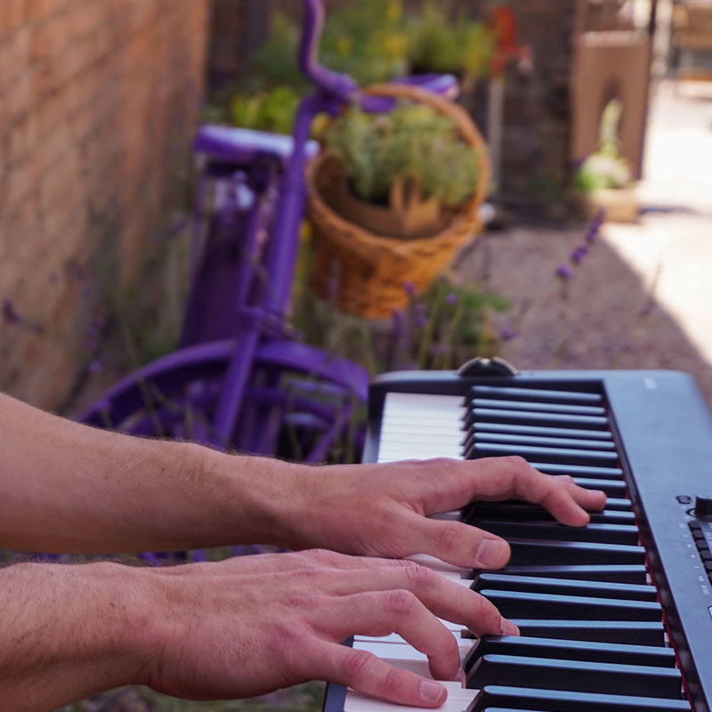 closeup of person's hands playing the piano outside in courtyard